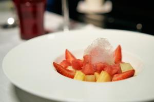 a white plate topped with fruit and vegetables at Palace Bonanza Playa Resort & SPA by Olivia Hotels Collection in Illetas