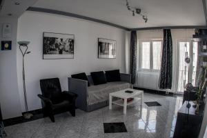 een woonkamer met een bank en een stoel bij Deák design apartment in Boedapest
