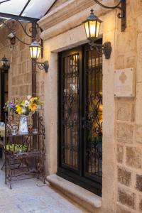 a building with a black door with flowers and lights at Boutique Hotel Stari Grad in Dubrovnik