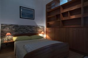 een slaapkamer met een groot bed en houten kasten bij Apartments Ivana in Postira