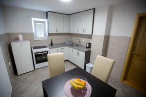 a kitchen with a table with a bowl of fruit on it at Apartman Miloš in Trebinje