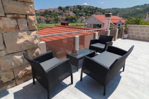 a group of chairs and a table on a patio at Apartments Ivana in Postira
