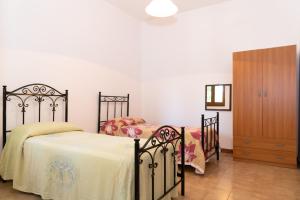サン・フォカにあるVilla Limoni 7 posti letto - San Focaのベッドルーム1室(ツインベッド2台、ドレッサー付)