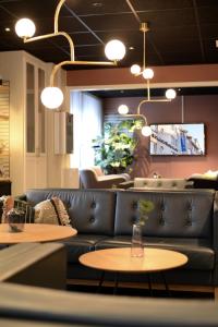 un soggiorno con divano e 2 tavoli di Comfort Hotel Arctic a Luleå