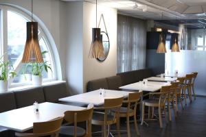 a row of tables and chairs in a restaurant at Comfort Hotel Arctic in Luleå