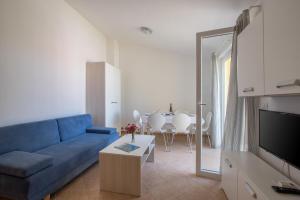 - un salon avec un canapé bleu et une table dans l'établissement Apartmani Svjetionik, à Umag