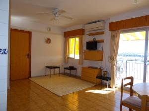 sala de estar con ventilador de techo y TV en Brisas del Mar Azul, en Torrevieja