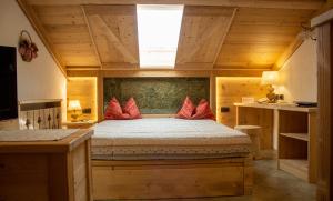 1 dormitorio con 1 cama con almohadas rojas en Residence Lastè, en Moena