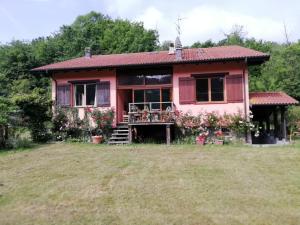 a pink house with a yard at Il pettirosso di Giusvalla in Giusvalla