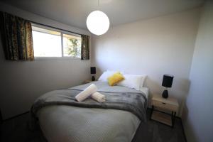 a small bedroom with a bed with a window at Rejuvenate on Rata FREE WIFI in Twizel