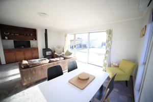 een woonkamer met een tafel en een bank bij Rejuvenate on Rata FREE WIFI in Twizel