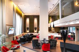 a hotel lobby with chairs and a bar at Pestana Arena Barcelona in Barcelona