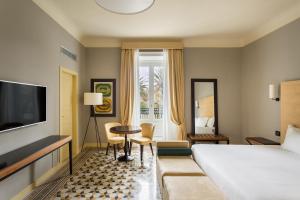 特拉帕尼Room Of Andrea Hotel的一间带床、桌椅的酒店房间