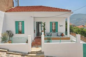 a white house with a gate and a balcony at Spring Bliss Garden House in Skopelos Town