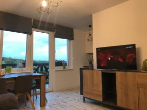 a living room with a television and a dining table at GOJA in Sztutowo