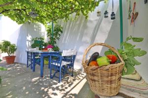 una cesta de frutas y verduras en un patio en Spring Bliss Garden House, en Skopelos Town