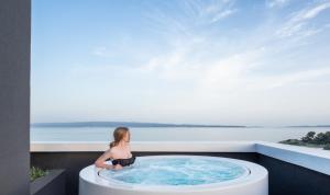 a woman is standing in front of a pool of water at briig boutique hotel in Split