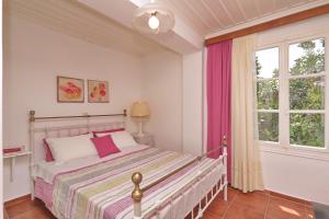 un dormitorio con una cama y una ventana en Spring Bliss Garden House, en Skopelos Town