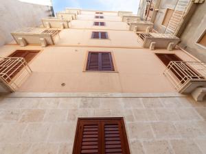 a tall building with windows and balconies on it at Casa Vacanze Tridente in Trapani