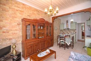 una sala de estar con un gran armario de madera y una mesa. en Spring Bliss Garden House, en Skopelos Town