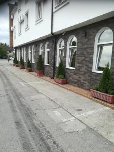 a building with potted plants on the side of it at Hotel Stari Krovovi in Novi Sad