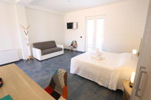 1 dormitorio con 1 cama blanca y 1 silla en Agriturismo Fattoria delle Milizie, en Scicli