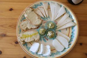 un plato de queso y pan en una mesa de madera en Agriturismo Fattoria delle Milizie, en Scicli