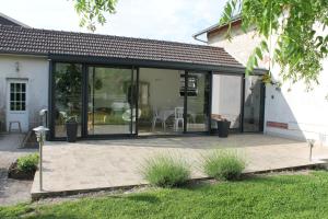 une extension en verre d'une maison avec un patio dans l'établissement La maison de TOINETTE, à Jonchery-sur-Suippe