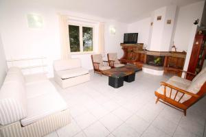 sala de estar con muebles blancos y chimenea en Villa Badde rosa, en Dorgali