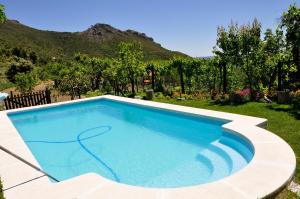 ein Schwimmbad in einem Garten mit Bergen im Hintergrund in der Unterkunft Casas Rurales Tio Frasquito y Cleto in Yeste