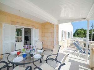 eine Terrasse mit einem Glastisch und Stühlen in der Unterkunft Apartment in Alcúdia with Bay of Pollensa View in Alcúdia