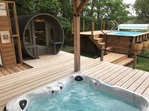 a hot tub on a deck with a gazebo at La Cabane à Papi in Thénac