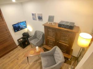 ein Wohnzimmer mit 2 Stühlen und einem TV in der Unterkunft Ameisenberg Appartement in Kurort Oybin