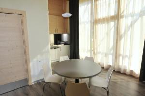 莫尔韦诺Bungalows Chalets Lago di Molveno的一间带桌子和白色椅子的餐厅