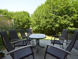 einen Tisch und Stühle auf einer Terrasse mit Bäumen in der Unterkunft Gorgeous Holiday Home in Daverdisse with Garden in Daverdisse