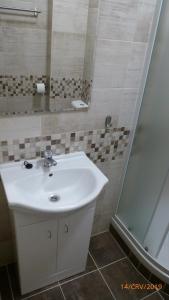 a bathroom with a white sink and a shower at Penzion Sklář in Nový Bor