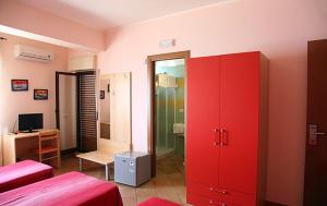 een kamer met 2 bedden en een rode kast bij Splash's Rooms in Spadafora
