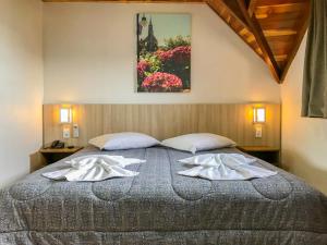 ein Schlafzimmer mit einem großen Bett mit Handtüchern darauf in der Unterkunft Hotel Triveneto Gramado in Gramado