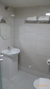 a white bathroom with a sink and a shower at Penzion Sklář in Nový Bor