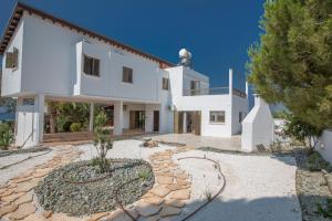 a large white house with a stone driveway at Rosie Villa in Ayia Napa