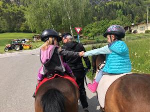 a couple of girls riding on the backs of horses at Haflingerhof in Kramsach