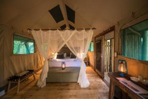 - une chambre avec un lit à baldaquin dans l'établissement Bundox Safari Lodge, à Hoedspruit