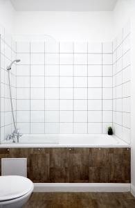 La salle de bains blanche est pourvue d'une baignoire et de toilettes. dans l'établissement Aisiki Living at Alexandra Road, 2-Bedroom & 2-Bathroom with King or Twin Beds with Free Wi-Fi & Parking Space, à Watford