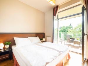a bedroom with a bed and a large window at VacationClub – Diune Apartament 38 in Kołobrzeg +15 photos
