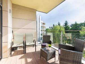 a balcony with wicker chairs and a table on a building at VacationClub – Diune Apartament 38 in Kołobrzeg