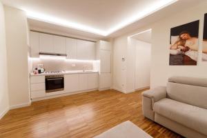 a living room with a couch and a kitchen at I VICOLI Exclusive Apartments in Fondi