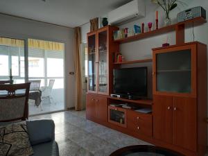 a living room with a television in a wooden entertainment center at Apartamento Torrox Costa in Torrox Costa