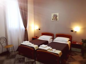 - une chambre avec 2 lits et une fenêtre dans l'établissement Chiostro Delle Cererie, à Matera