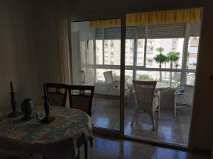 a living room with a table and chairs and a window at Apartamento Torrox Costa in Torrox Costa