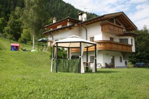 a house with a gazebo in front of it at B&B Rendena Chalet in Strembo